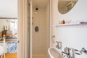 A modern bathroom with a shower, sink, and mirror. - Panoramic Family Home in Maida Vale (London)