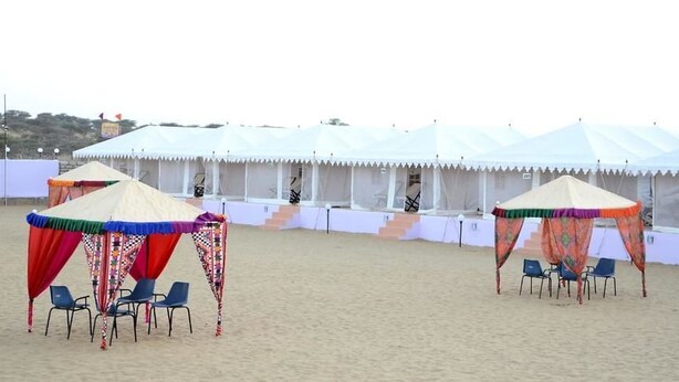 A beach with two tents and chairs. - Sam Desert Den (Jaisalmer)