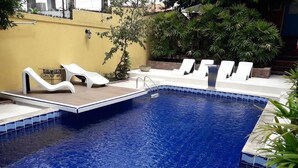 Una piscina amb gandules blanques i un pont de fusta.