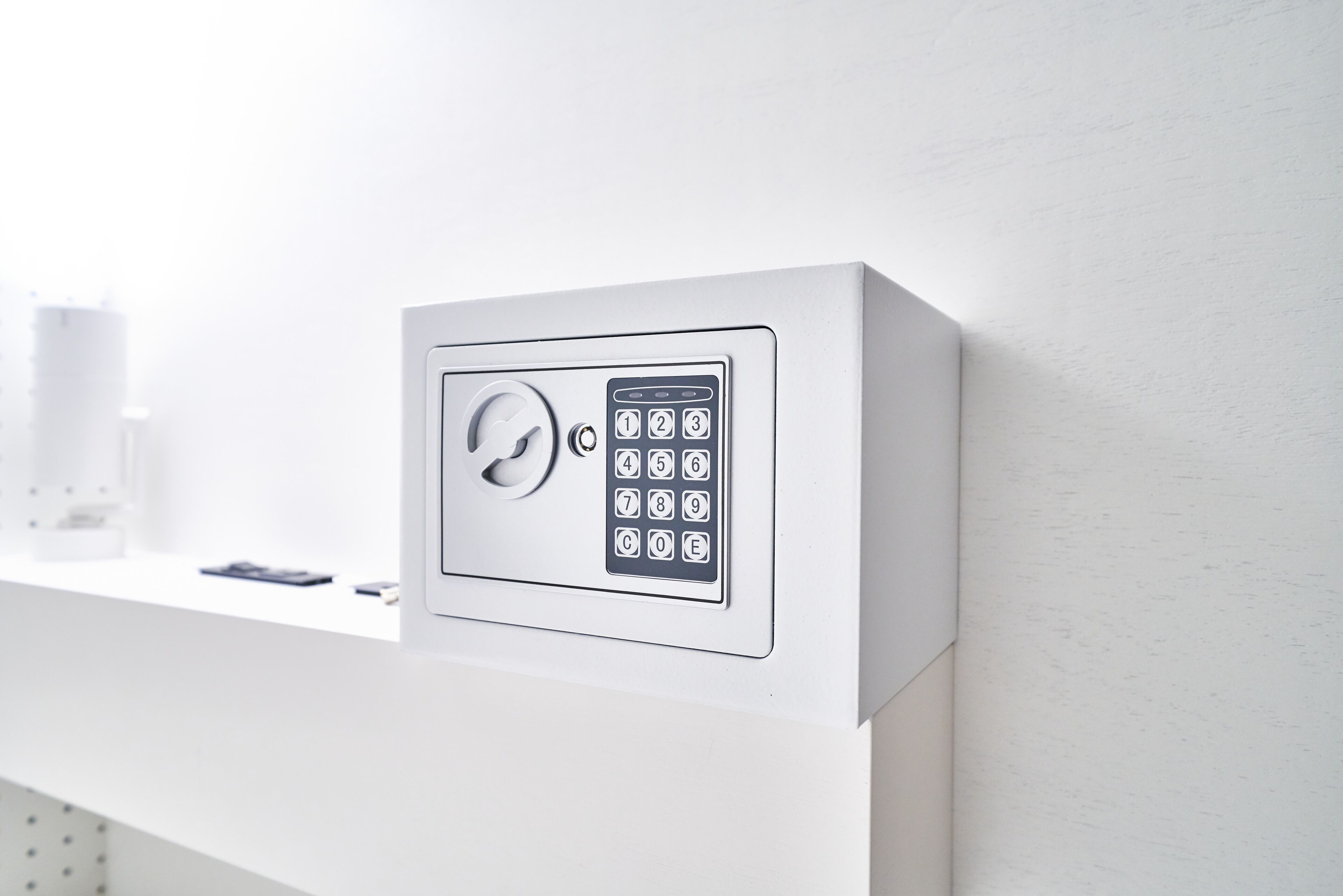 A wall-mounted security keypad with a numeric keypad and a keyhole.