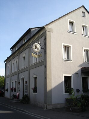 A building with a sign for "Wolf Bier" and "Gasthof Lutz Fremdenzimmer" indicating it is a hotel with a beer brand and a guesthouse. - Fränkischer Gasthof Lutz (Giebelstadt)