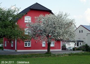 A red building with white windows and a tree in front. - Fränkischer Gasthof Lutz (Giebelstadt)