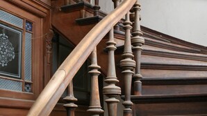 A wooden staircase with ornate balusters and a curved handrail. - Villa Bianca am Huy (Huy)