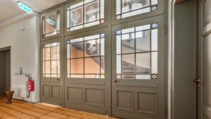 A set of double doors with decorative glass panels and a wooden floor. - Villa Bianca am Huy (Huy)