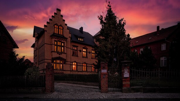 A historic building with a traditional architectural style, featuring multiple windows and a brick facade. - Villa Bianca am Huy (Huy)