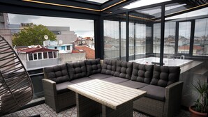 Un balcón moderno con un sofá modular, una mesita y una planta en maceta.
