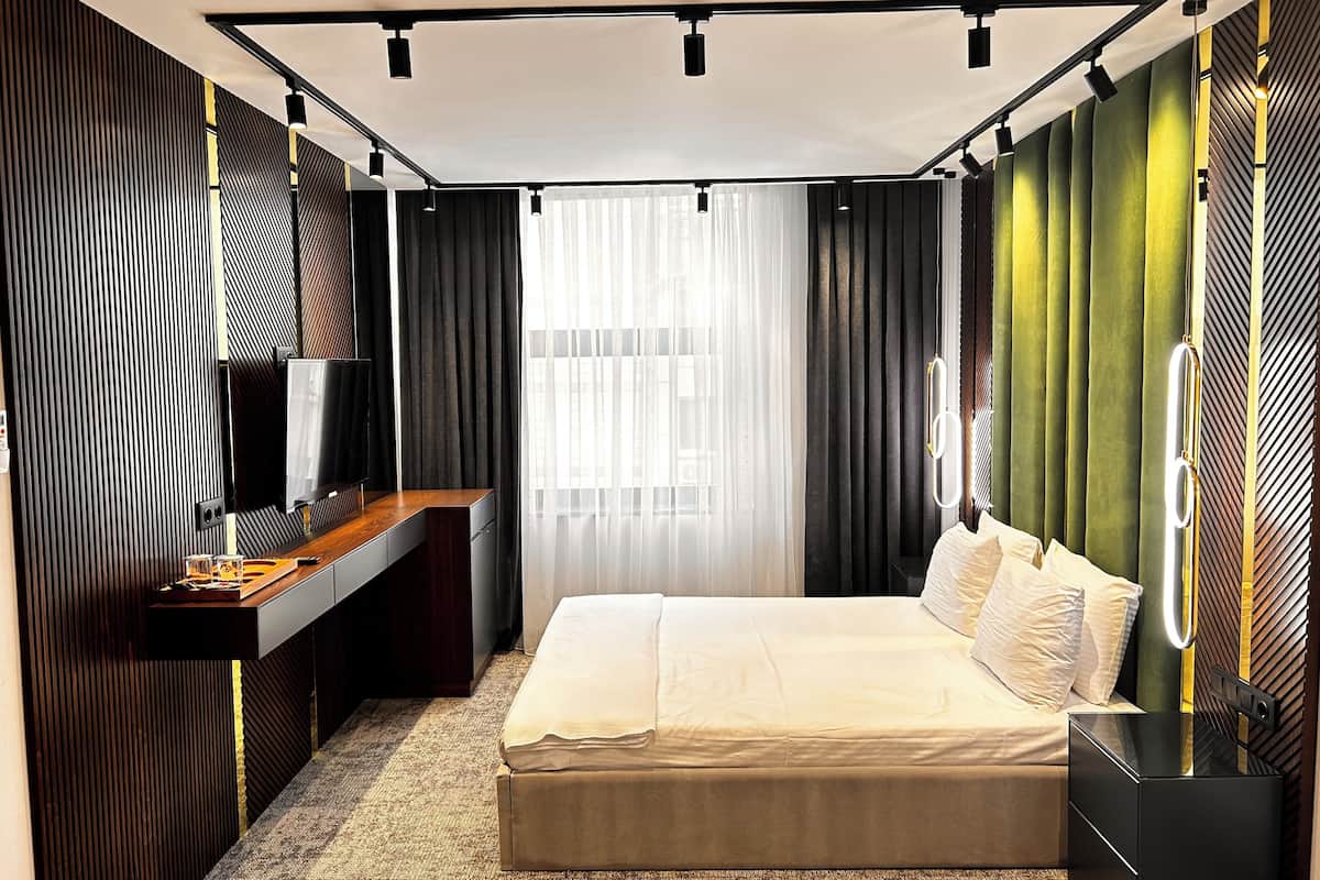 Une chambre moderne avec un grand lit, un bureau et une télévision.