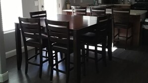 A kitchen with wooden cabinets, a dining table with chairs, and an exit sign above a door. - The Zion Getaway-Located in beautiful Southern Utah (La Verkin)