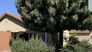 A residential house with a sloped roof, a brick foundation, and a gravel driveway. - The Zion Getaway-Located in beautiful Southern Utah (La Verkin)