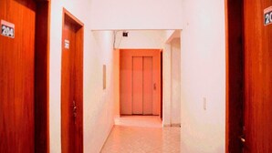 A hallway with wooden doors, each marked with a number. - Hotel Pais e Filhos (São João del Rei)