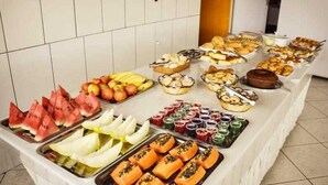 A buffet with various food items including fruits, pastries, and desserts. - Hotel Pais e Filhos (São João del Rei)