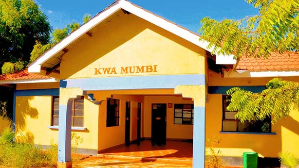 A building with the sign "KWA MUMBI" on the front.