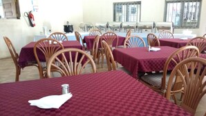 Un comedor con mesas cubiertas de manteles a cuadros rojos y sillas de madera.