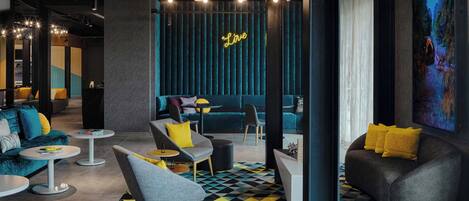 A modern lounge area with seating, a neon 'Love' sign, and a geometric patterned floor.