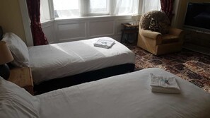 Tabla de planchar con plancha y ropa de cama