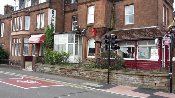 A traditional brick building with a red awning and a shop on the ground floor. - LSO GUEST HOUSE  (Dumfries)
