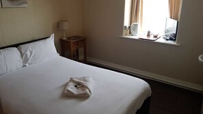 Tabla de planchar con plancha y ropa de cama