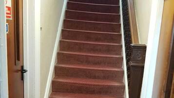 Una escalera empapelada con un extintor a la izquierda.