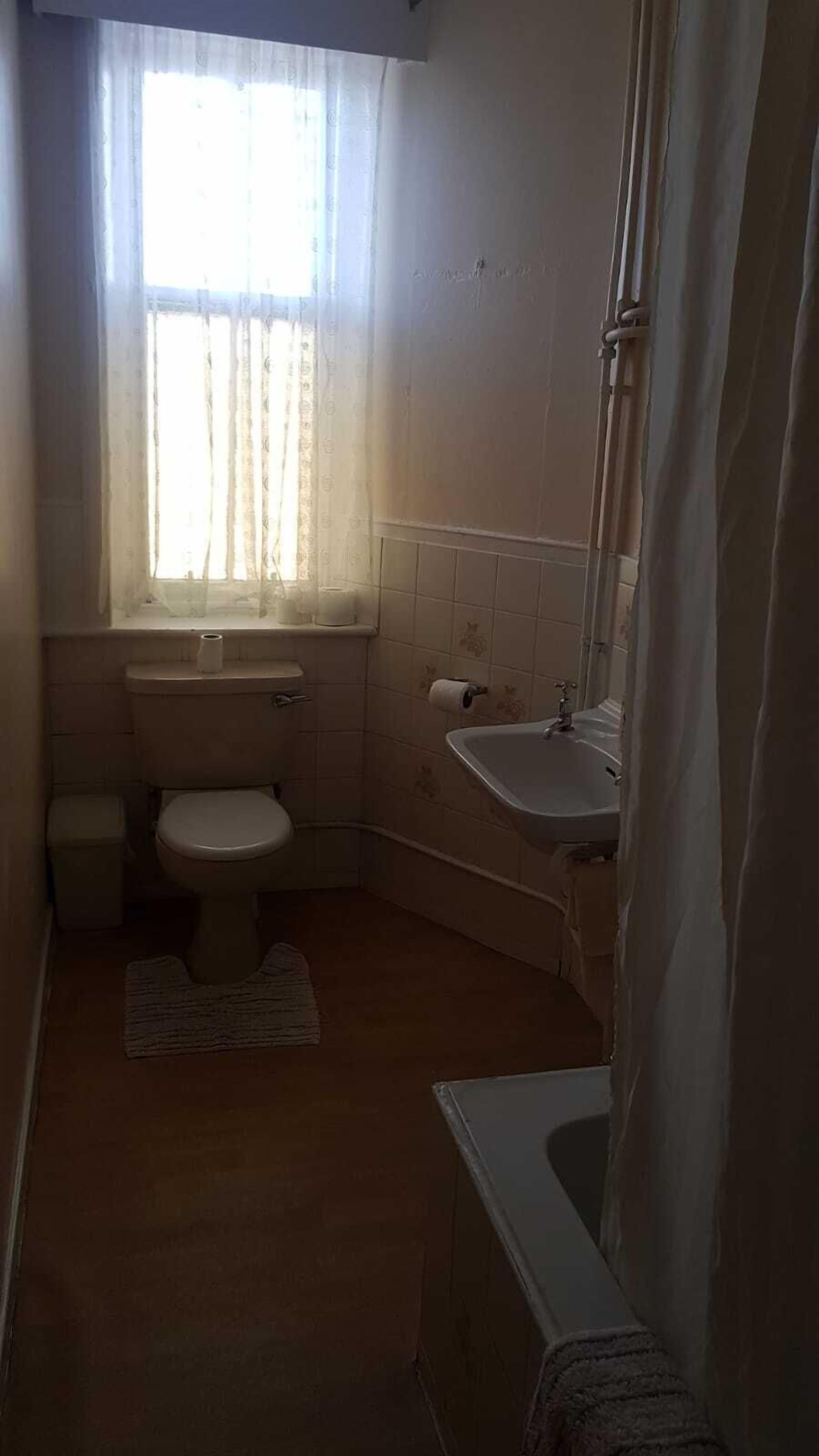 Ein kleines, kompaktes Badezimmer mit Toilette, Waschbecken und Duschbereich.