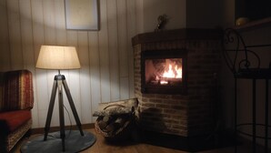 A cozy room with a brick fireplace, a standing lamp, and a wicker basket of logs. - very quiet rural house (hodeng-hodenger)