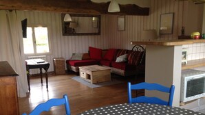 A cozy living room with a sofa, a coffee table, and a dining table with chairs. There is a window with curtains, a lamp, and a mirror on the wall. - very quiet rural house (hodeng-hodenger)
