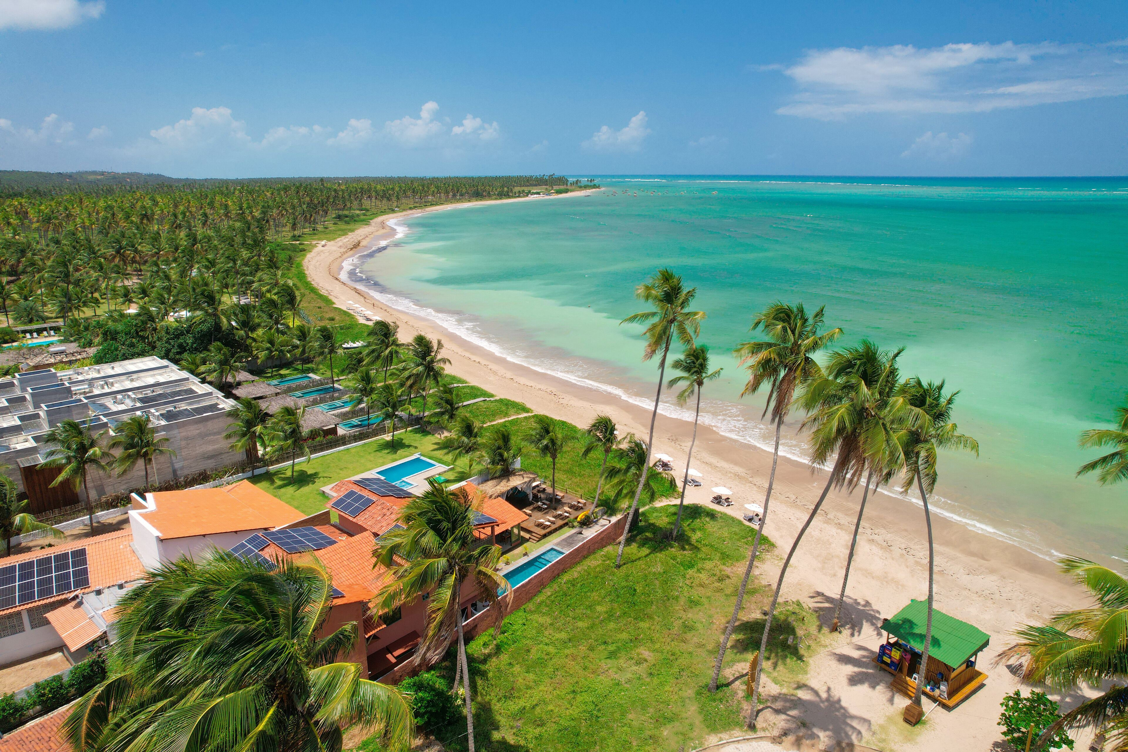 Ein Küstenresort mit Strand, Palmen und Poolbereich.