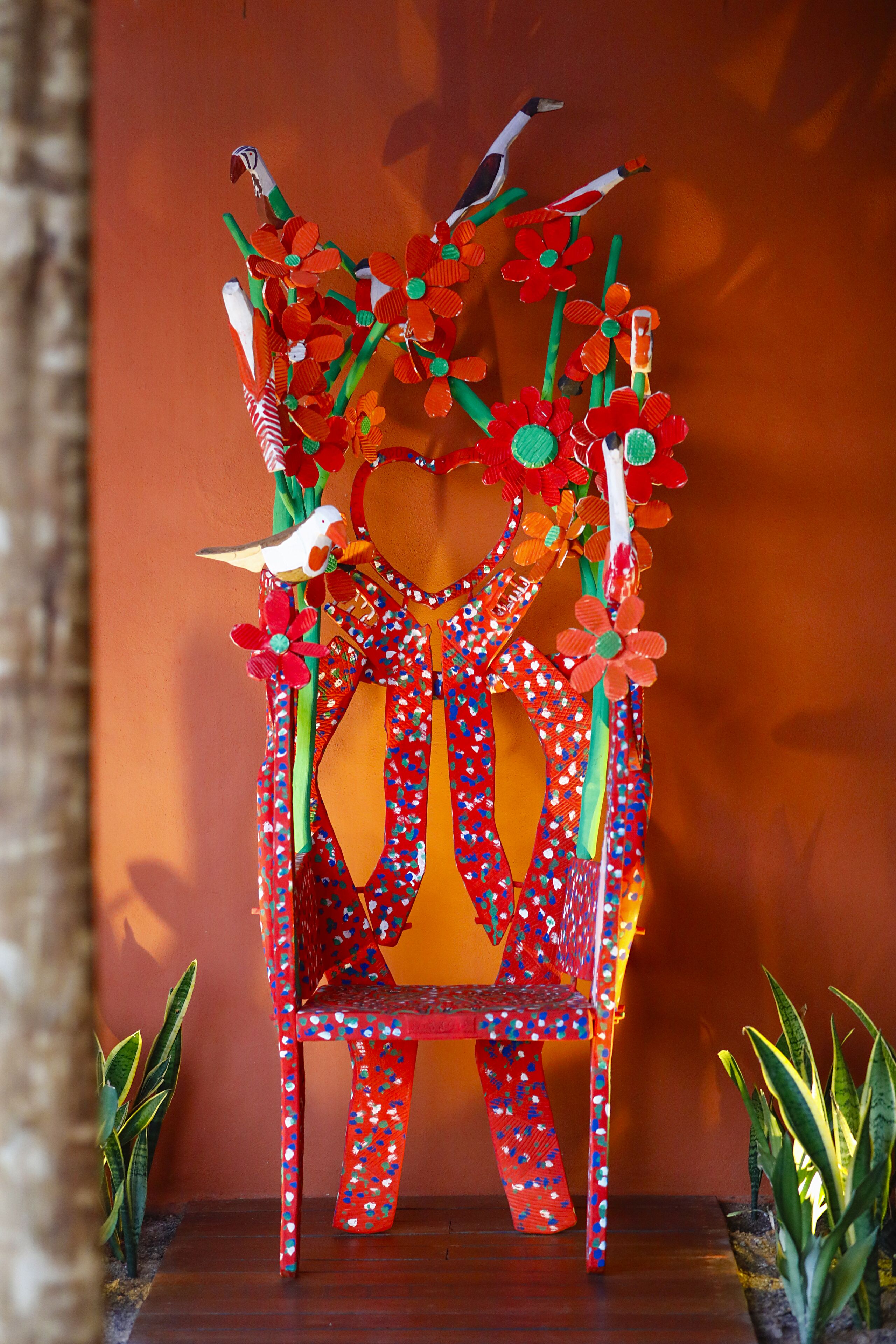 A chair with a colorful, abstract design, featuring red and blue patterns and green accents.