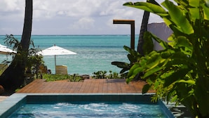 A pool with a view of the ocean, surrounded by palm trees and lounge chairs. - Pousada Rota Ecológica (Porto de Pedras)