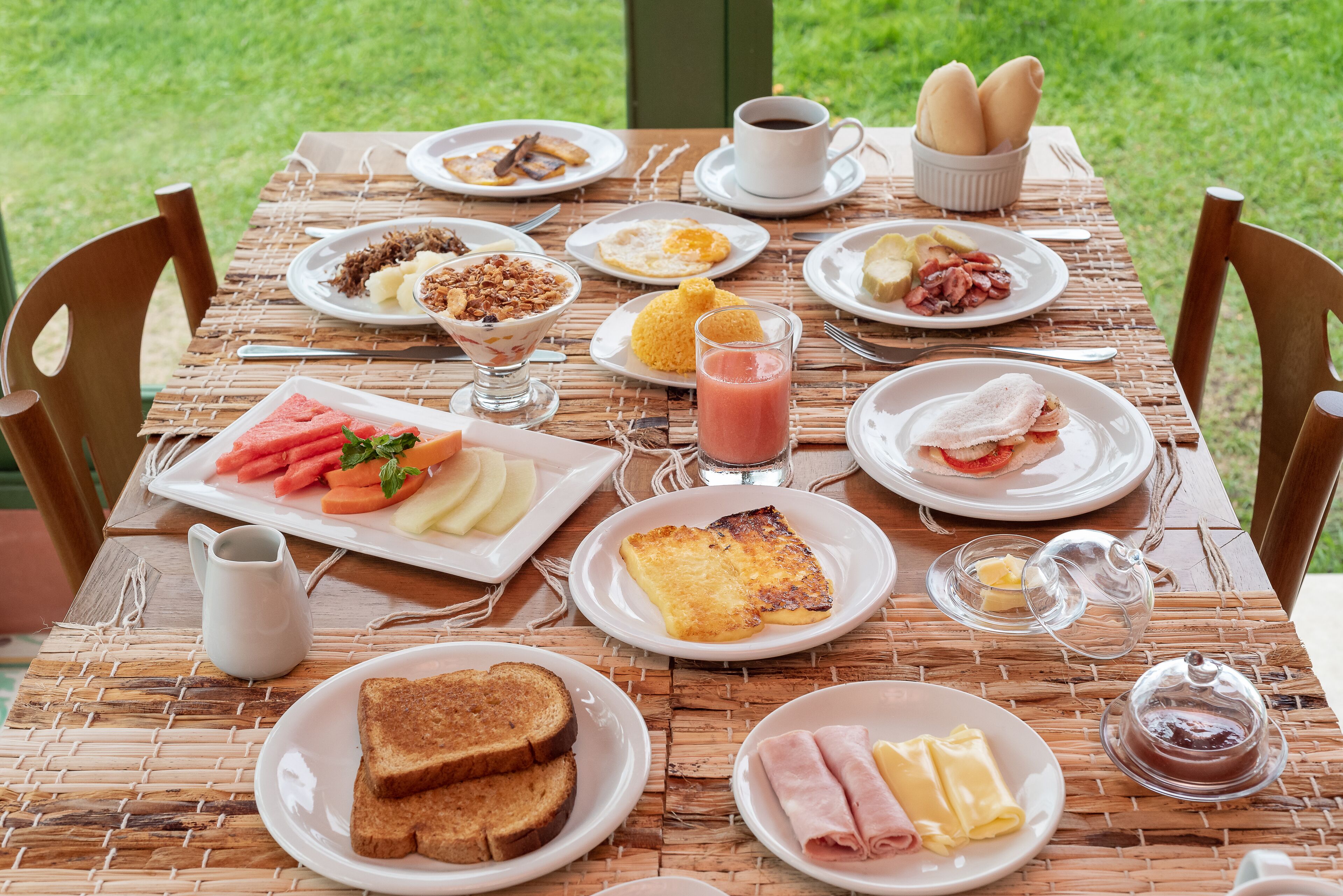 A breakfast table with various dishes including toast, eggs, and fruit.
