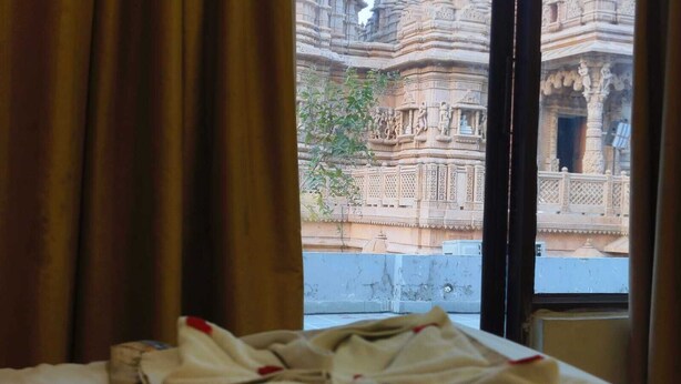 Blick aus dem Fenster auf einen Tempel mit aufwendigen Schnitzereien.