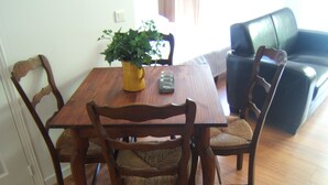 Una mesa de comedor con cuatro sillas de madera, una planta en maceta y un objeto decorativo pequeño.