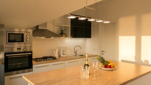 A modern kitchen with stainless steel appliances, a wooden countertop, and a fruit bowl. - Apartments Villa Dubrovnik (Konavle)