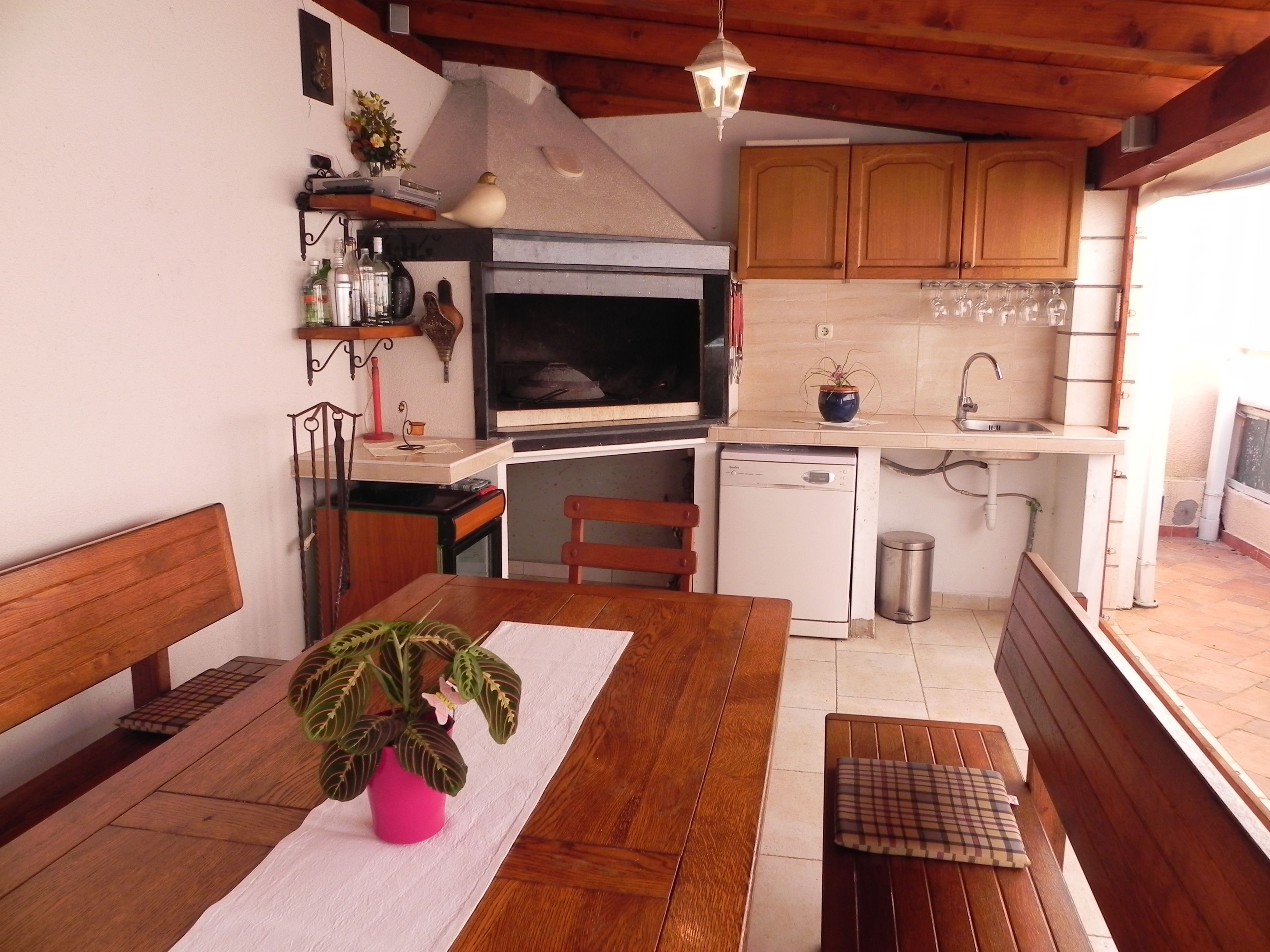 A compact kitchen with wooden cabinets, a built-in oven, and a sink.
