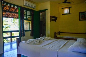 Una habitación con dos camas, aire acondicionado, ventilador de techo y una ventana con cortinas.