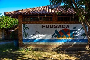 Un edificio con techo de tejas y un mural en la fachada.