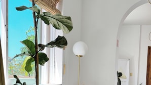 A spacious living area with large potted plants, wicker furniture, and a modern floor lamp. - 3B| Wellness Hotel & Hostel (Playa del Carmen)