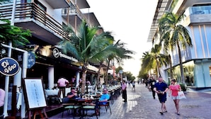 A street lined with palm trees and outdoor seating at a restaurant. - 3B| Wellness Hotel & Hostel (Playa del Carmen)