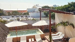 A rooftop pool area with lounge chairs and umbrellas, surrounded by a wooden pergola. - 3B| Wellness Hotel & Hostel (Playa del Carmen)