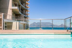 Um hotel moderno com piscina e vista para o oceano.