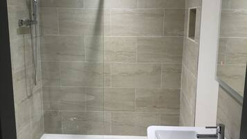 Une salle de bain moderne équipée d’une douche, de toilettes et d’un lavabo.
