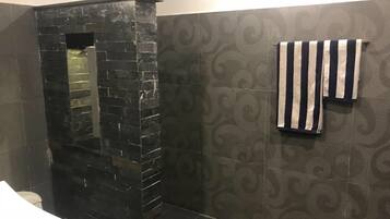 Ducha y bañera combinadas, toallas, jabón y champú