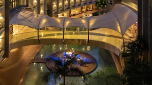 Een modern hotel met een zwembadgedeelte, terras en een overdekte doorgang.