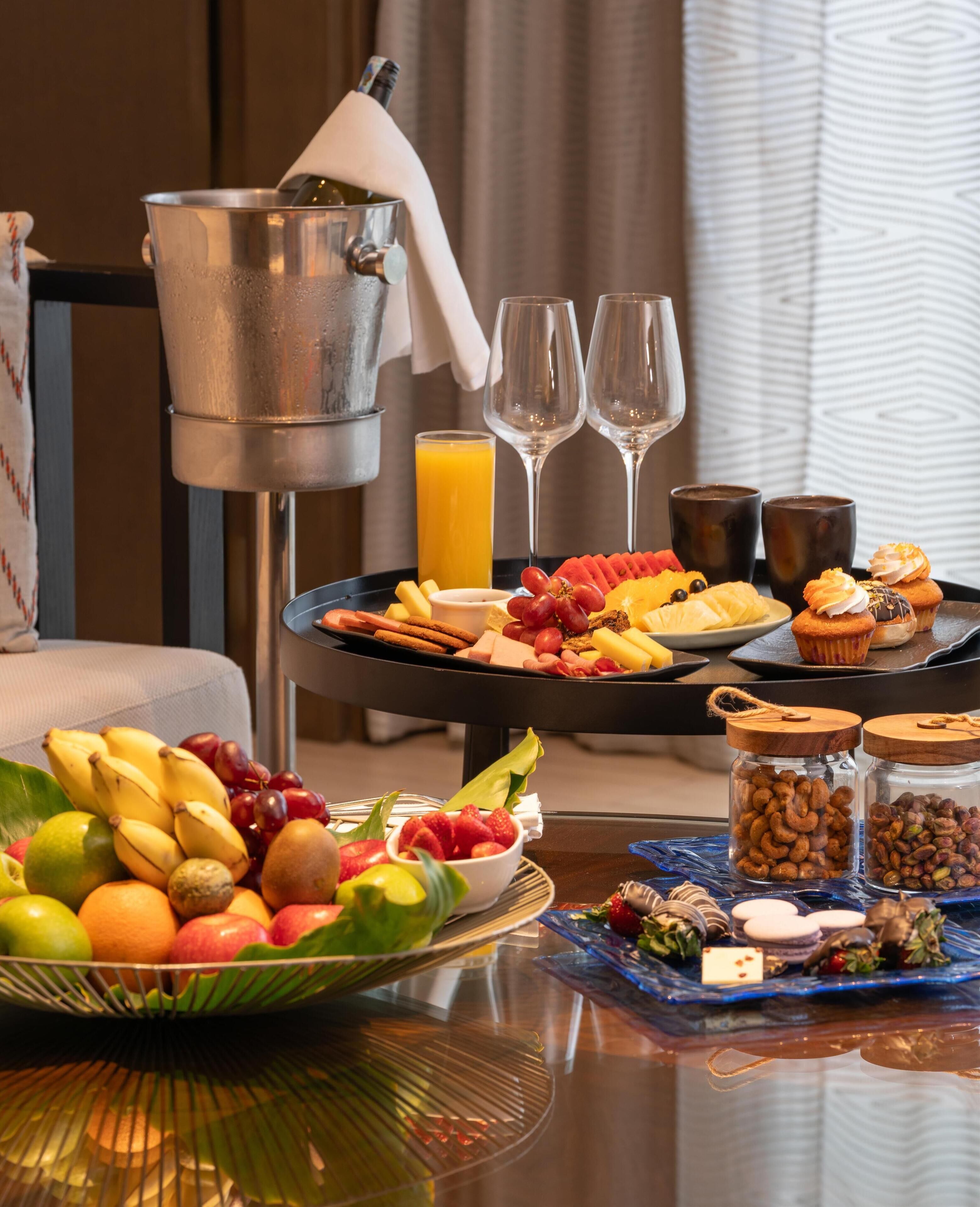 A breakfast buffet with fruits, pastries, and beverages.