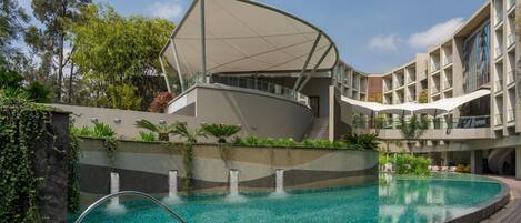 Een buitenzwembad, parasols bij het zwembad en ligstoelen