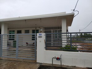 Guests enter through a secure gated entrance, featuring a metal gate and water spigot.
