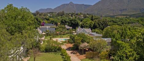 A residential area with houses, a swimming pool, and mountains in the background.