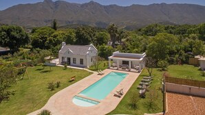 Une propriété résidentielle dotée d’une piscine, d’un patio couvert et offrant une vue sur les montagnes.