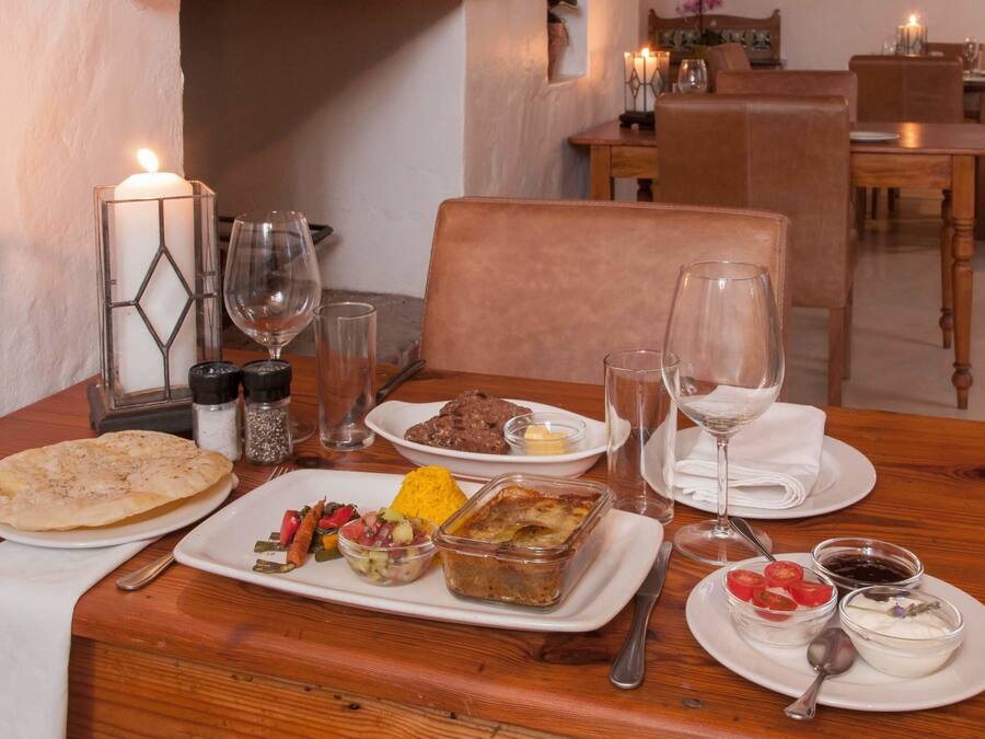 A dining table set with various dishes, glasses, and a candle.