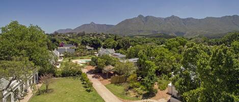 A residential area with houses, a well-maintained lawn, and a mountain range in the background.