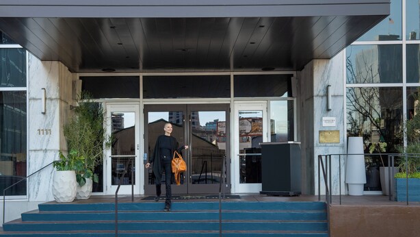 The entrance to The Troubadour with a modern design, featuring a glass facade and a set of stairs leading up to the door. - Troubadour Hotel (New Orleans)